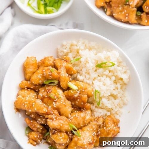 Whole30 sesame chicken over cauliflower rice in a bowl