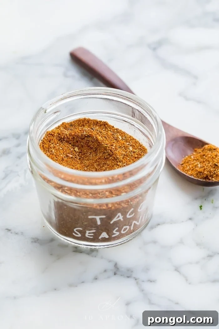 taco seasoning in a glass jar on a marble surface