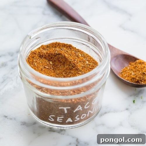 taco seasoning in a glass jar on a marble surface