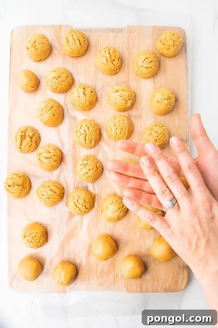 Keto Buckeyes 3 Hands rolling peanut butter mixture into small balls, demonstrating the easy no-bake preparation of Keto Buckeyes.