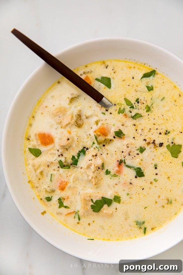 Creamy chicken and cauliflower rice soup garnished with fresh herbs, ready to be served from the Instant Pot.