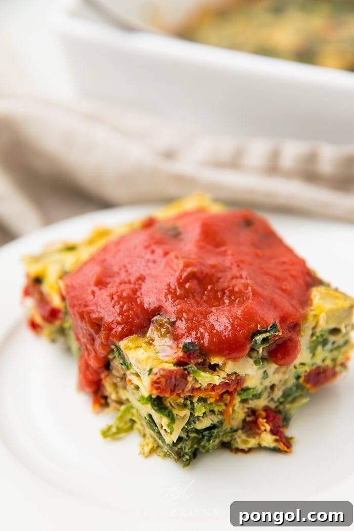 Italian breakfast casserole served on a white plate with red marinara sauce
