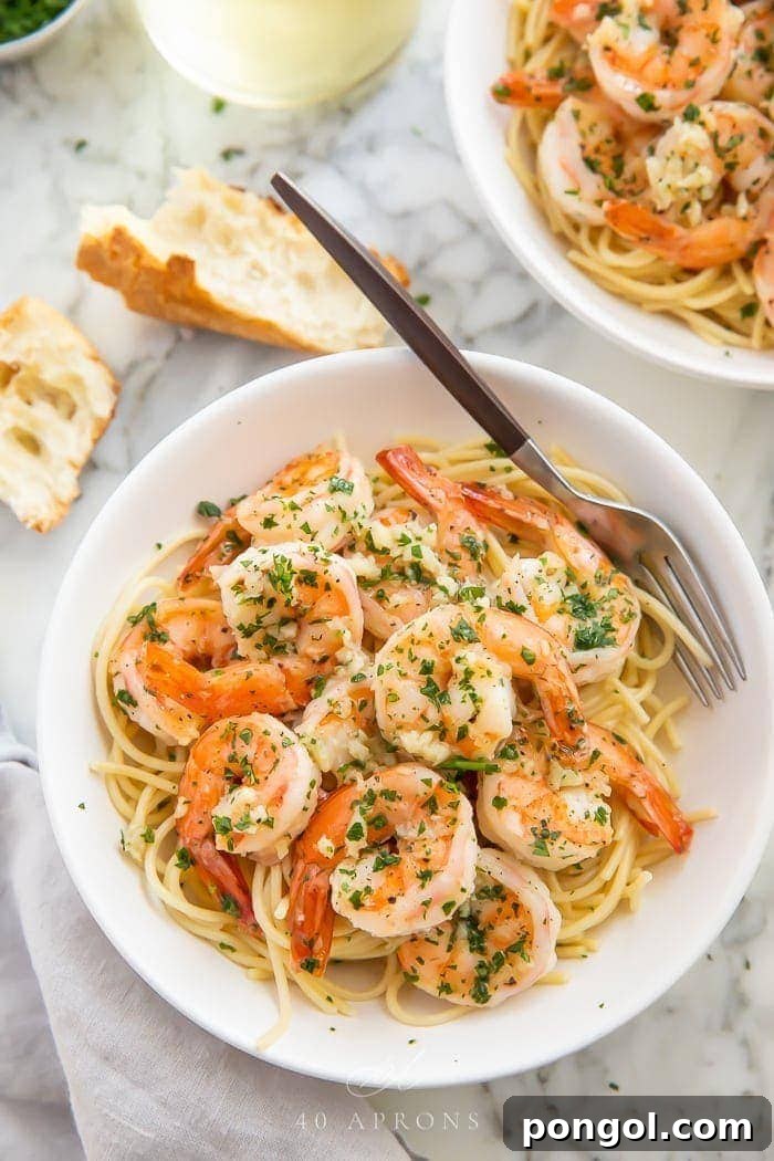 Savory Garlic Butter Shrimp 2 Shrimp with pasta served in a bowl with a fork, garnished with fresh parsley.