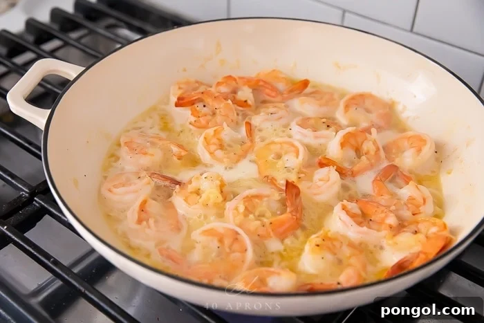 Savory Garlic Butter Shrimp 4 Garlic butter shrimp sizzling in a hot skillet, freshly cooked.