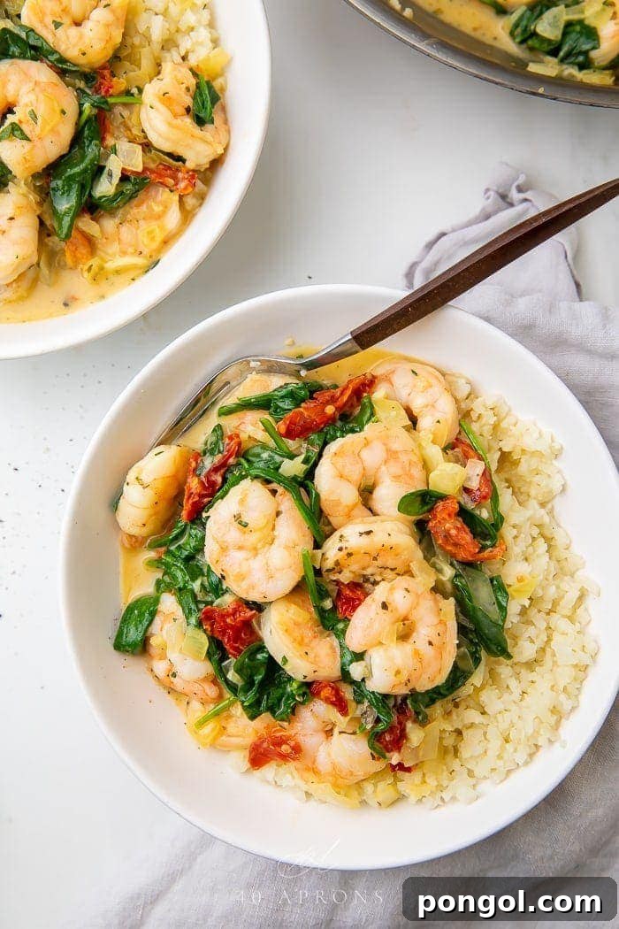 Healthy Whole30 Paleo Tuscan Shrimp 2 Close up of a bowl of creamy Tuscan shrimp with fresh spinach and sun-dried tomatoes