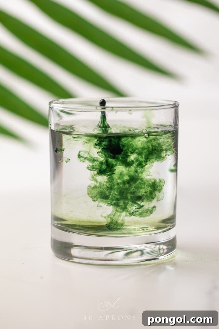 Liquid chlorophyll being dropped into a glass of water