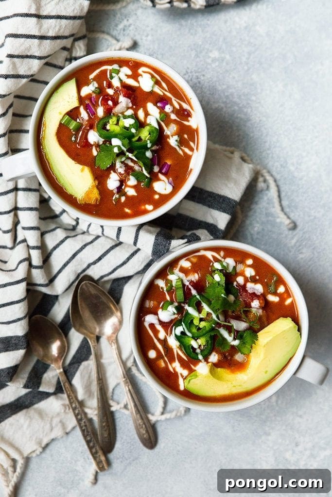 A rustic white bowl filled with rich Whole30 taco soup, garnished with fresh cilantro and a lime wedge, promising a burst of healthy flavor.