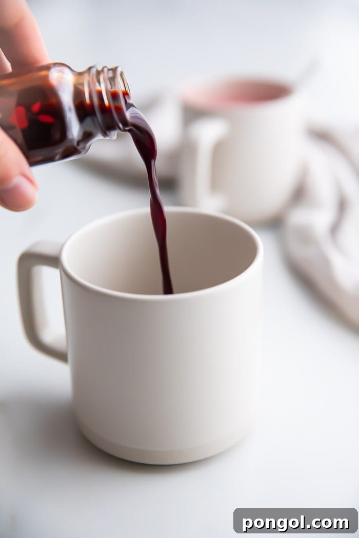 Pouring a beet shot into a white mug