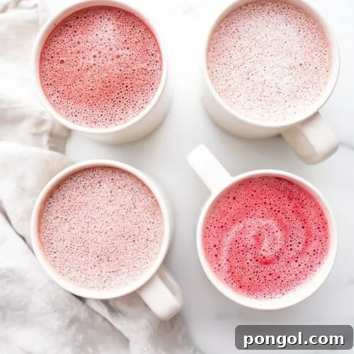 Four pink lattes in white mugs