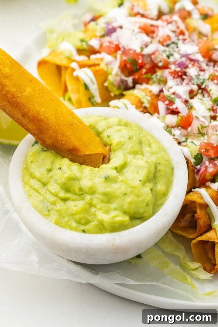 Bean and cheese taquito being dipped in avocado salsa