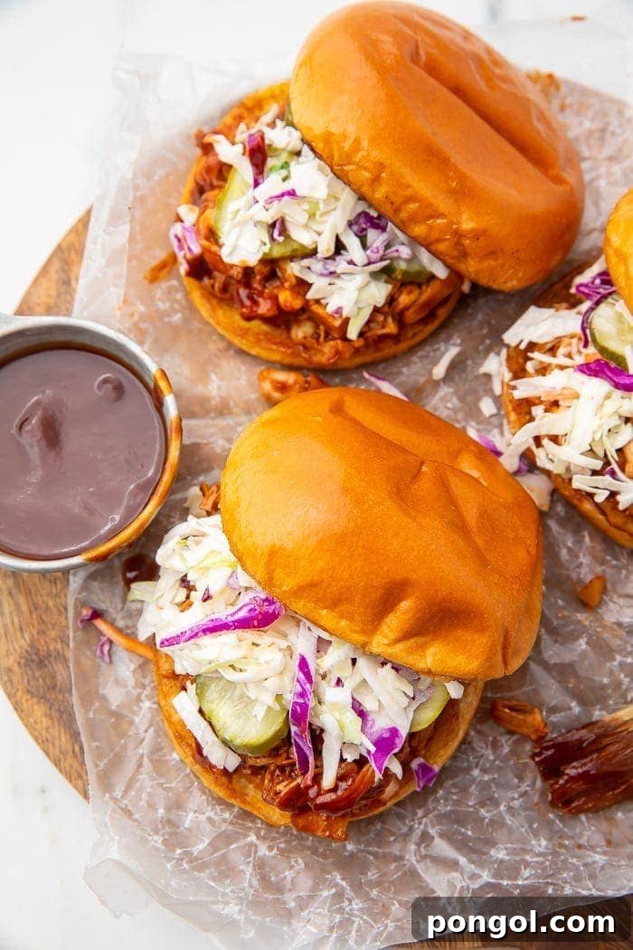 Smoky Pulled Jackfruit BBQ Sandwiches 3 Three vegan BBQ jackfruit sandwiches with a side of barbecue sauce