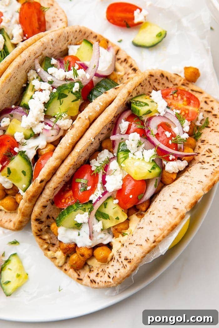 Two chickpea gyros on a white plate