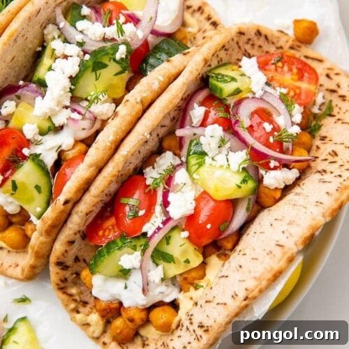 Two chickpea gyros on a white plate