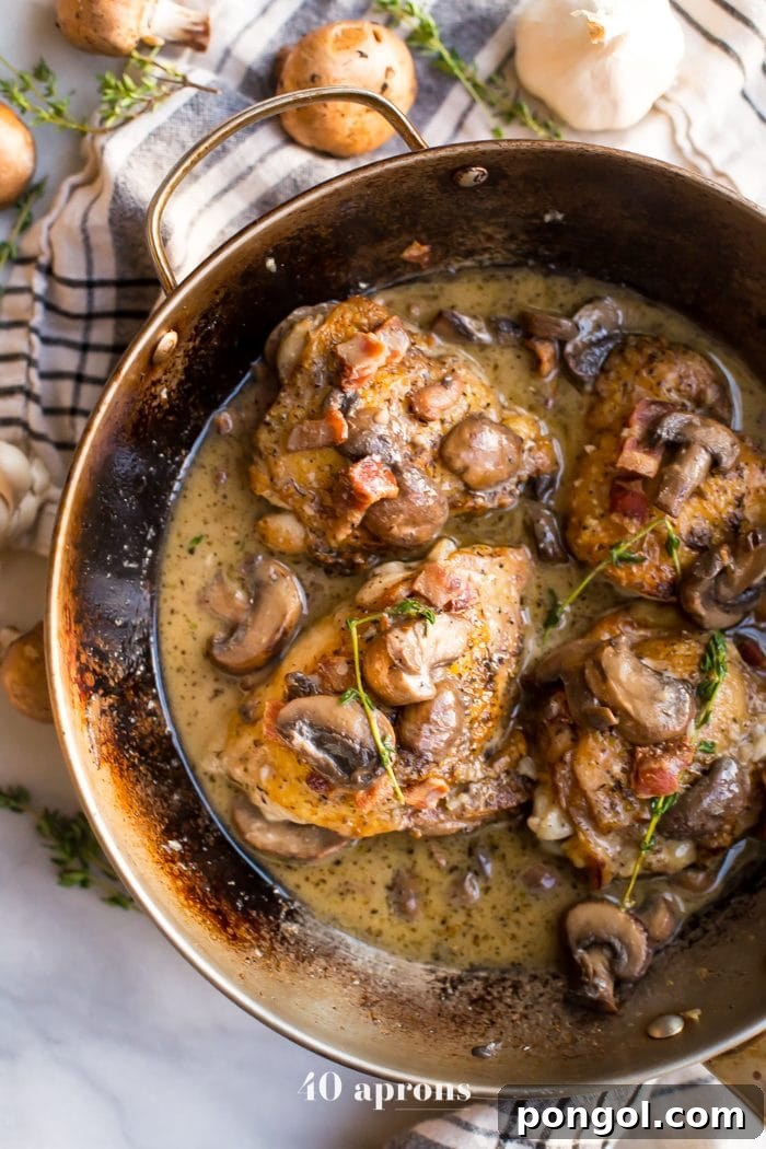 Flavorful Whole30 Dinner Ideas 10 Bacon and mushroom chicken thighs sizzling in a pan, coated in a creamy sauce.