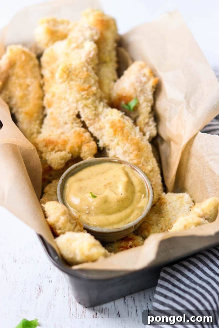 Flavorful Whole30 Dinner Ideas 11 Crispy Whole30 and Paleo coconut chicken served with a side of honey mustard sauce.