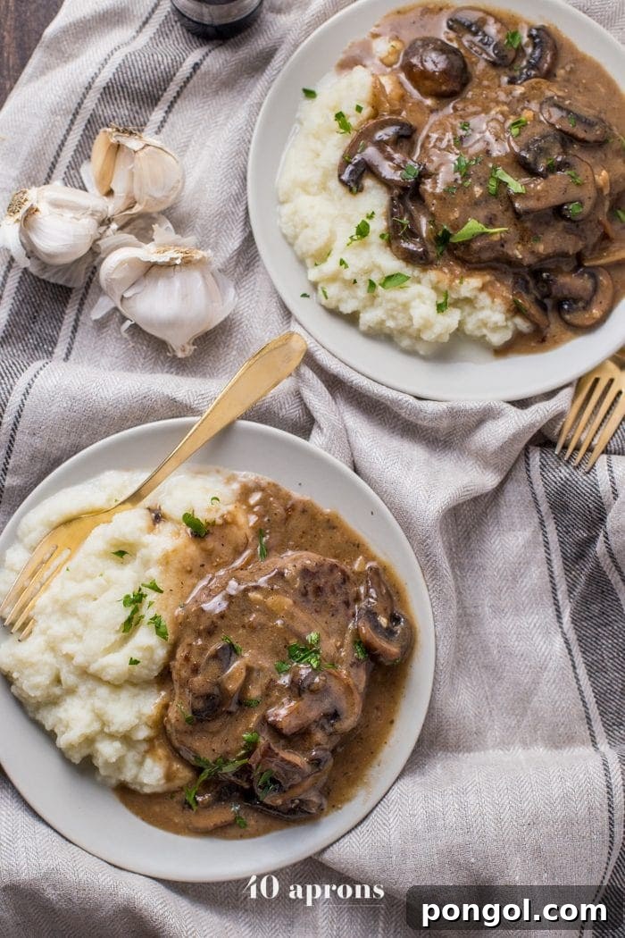 Flavorful Whole30 Dinner Ideas 27 Overhead shot of Whole30 Salisbury Steak served with creamy mashed potatoes and sprinkled with fresh chives.