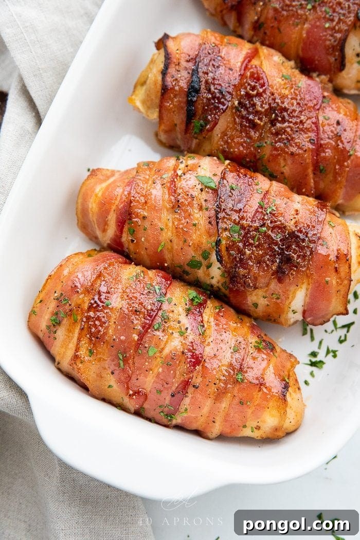 Flavorful Whole30 Dinner Ideas 3 Four crispy bacon-wrapped chicken breasts baking in a dish, showcasing a golden-brown crust.
