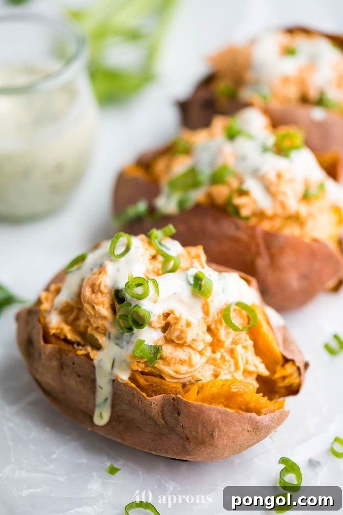 Flavorful Whole30 Dinner Ideas 13 Healthy creamy buffalo chicken stuffed sweet potatoes topped with ranch dressing and served with celery sticks.