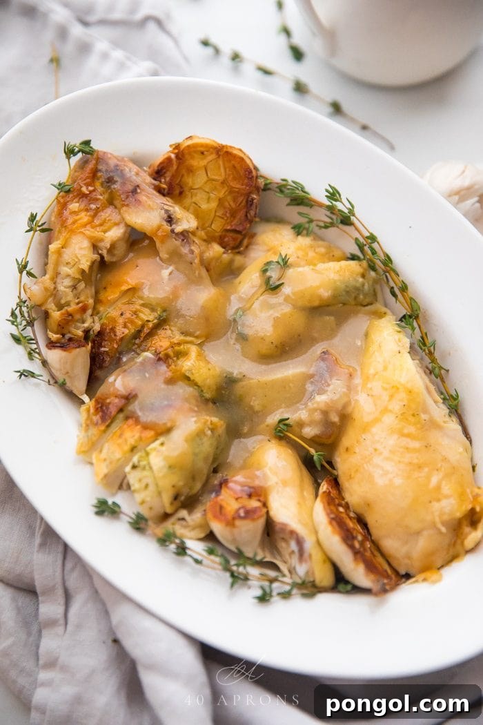 Flavorful Whole30 Dinner Ideas 18 Slow cooker roast chicken cut into pieces, topped with gravy and garnished with fresh thyme.