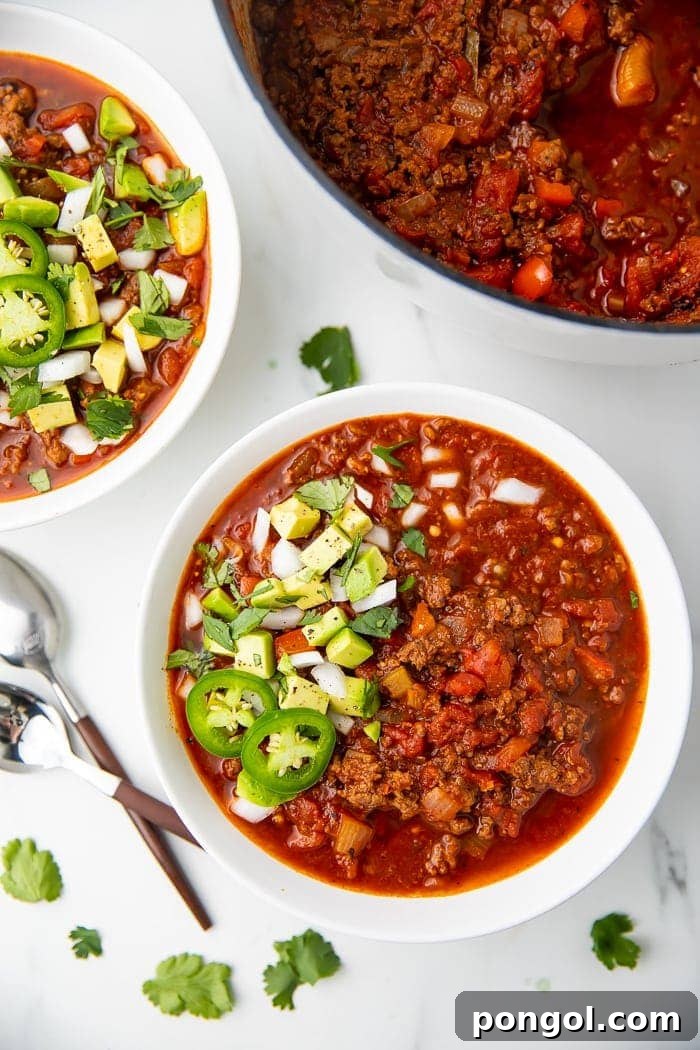 Flavorful Whole30 Dinner Ideas 30 A bowl of classic Whole30 chili, garnished with fresh jalapenos, diced red onions, and sliced avocados.