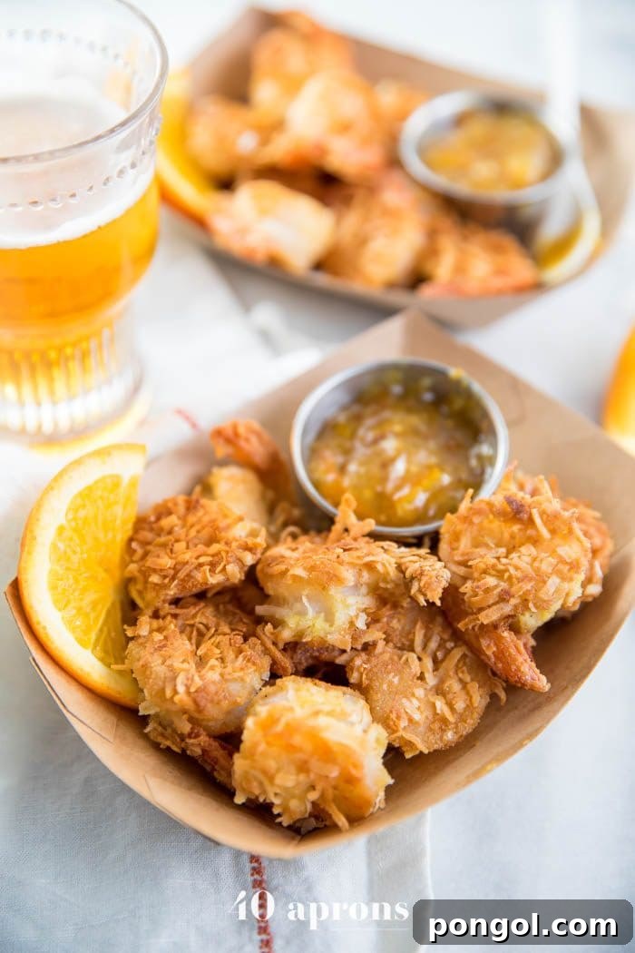 Flavorful Whole30 Dinner Ideas 40 Whole30 coconut shrimp with orange sauce, served in a container.