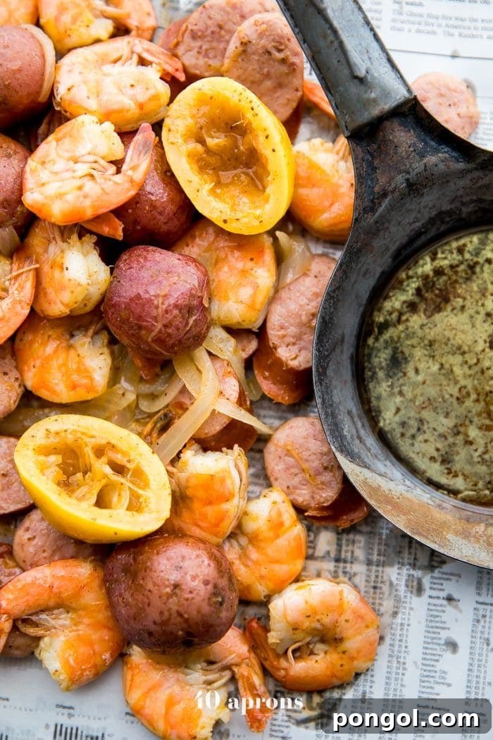 Flavorful Whole30 Dinner Ideas 42 Whole30 shrimp boil with sausage, potatoes, and garlic ghee spread on newspaper.