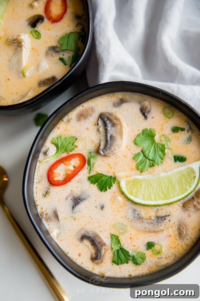 Flavorful Whole30 Dinner Ideas 6 A bowl of Best Ever Tom Kha Gai Soup, a Thai coconut chicken soup, rich and creamy, garnished with fresh herbs.