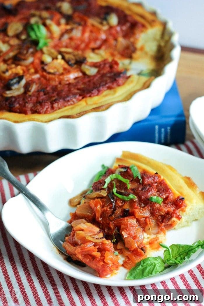Flavorful Whole30 Dinner Ideas 50 A Whole30 Tomato Tart, featuring fresh tomatoes and herbs, on a wooden surface.