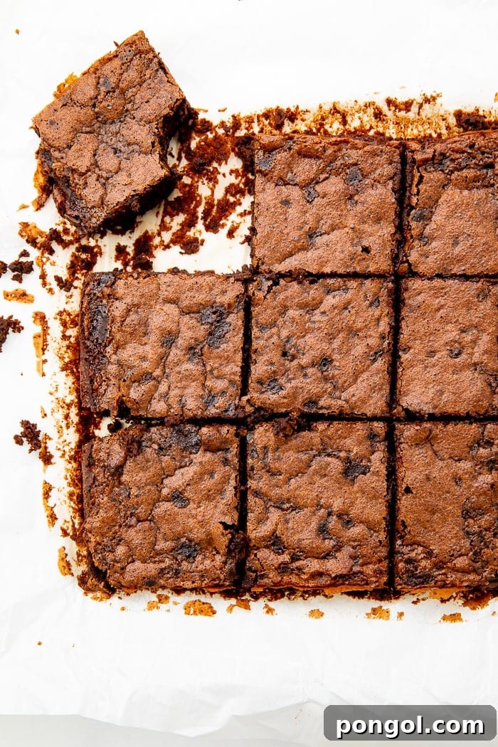 A pan of freshly baked black bean brownies, showing their rich, dark color and crackly top before being cut.