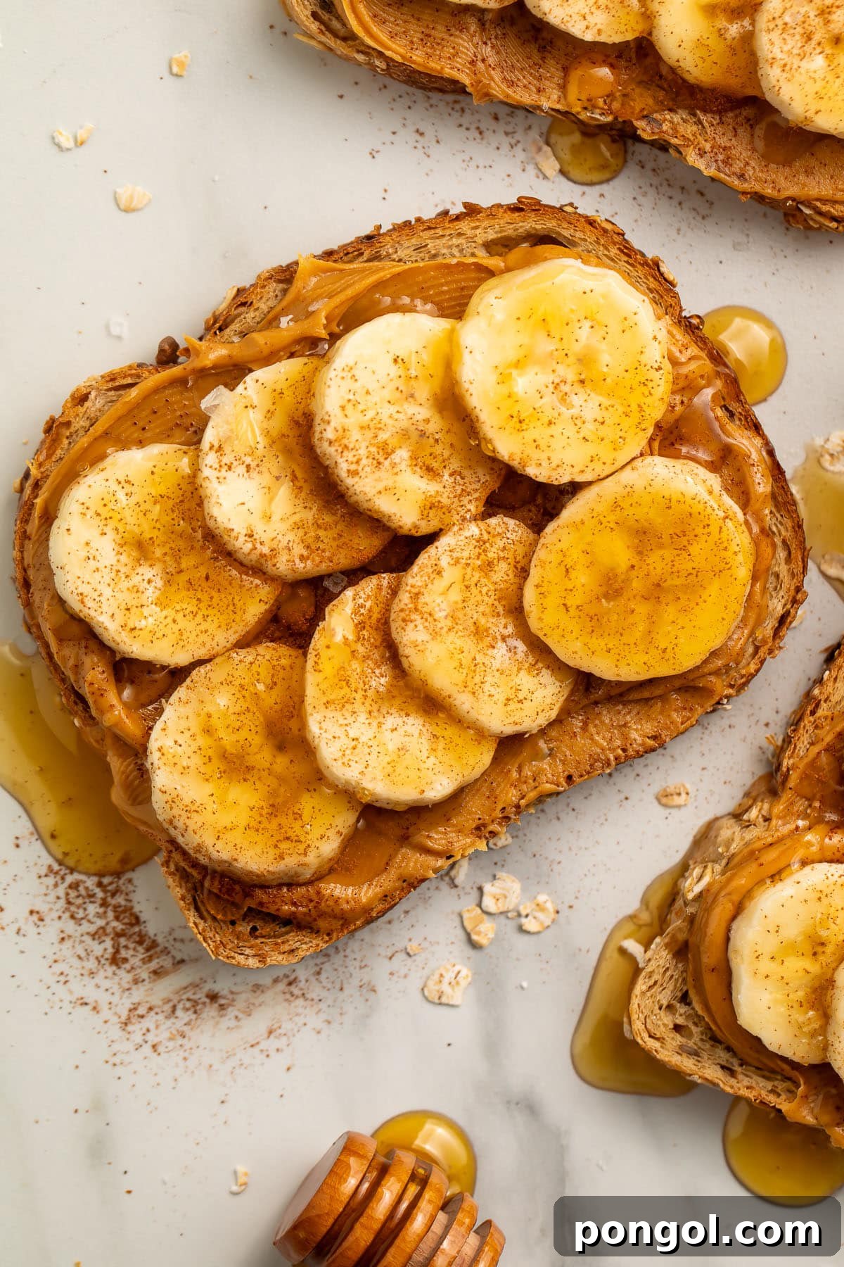 Golden PB Banana Bliss 3 Close-up view of a slice of peanut butter banana toast topped with honey, cinnamon, and sea salt.