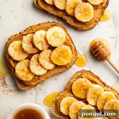 Overhead view of 3 slices of peanut butter banana toast drizzled with honey then topped with a dash of cinnamon and sea salt.