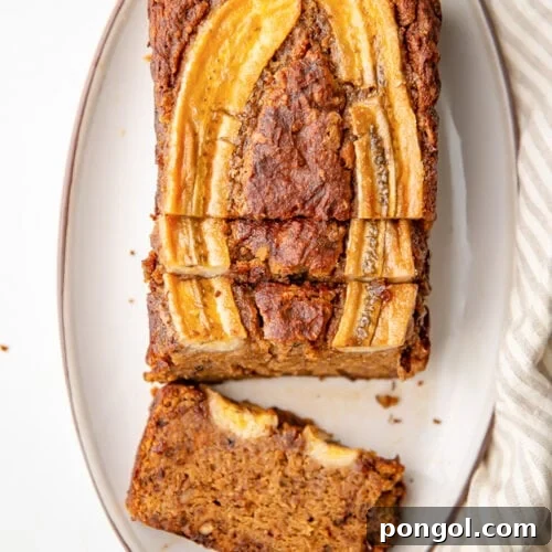Overhead view of an almond flour banana bread loaf, with a slice laying flat on the platter.