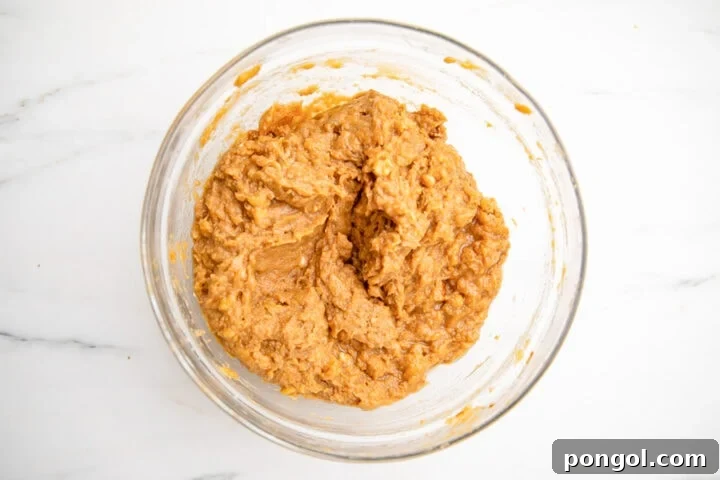 Paleo almond flour banana bread batter in large glass mixing bowl.