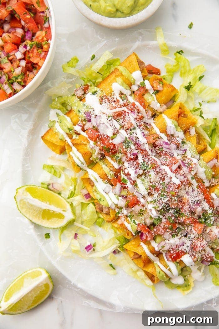 A plate of golden-brown bean and cheese taquitos, garnished with fresh limes, served alongside vibrant pico de gallo and creamy avocado for dipping.