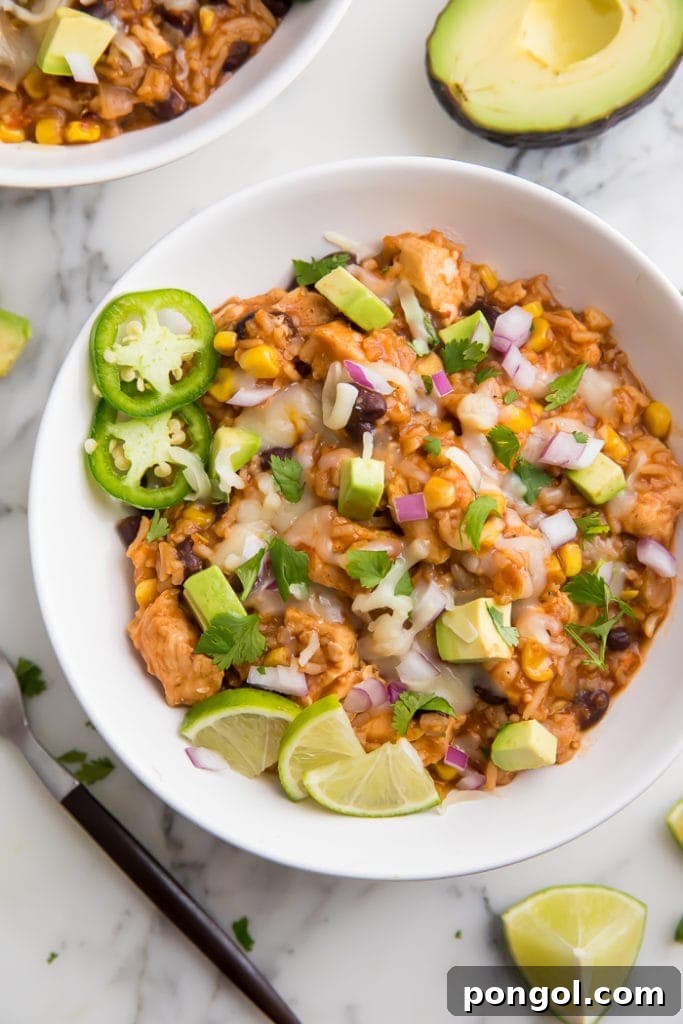 A vibrant Instant Pot burrito bowl, generously loaded with seasoned rice, tender chicken, black beans, corn, and fresh avocado, showcasing a complete one-pot meal.