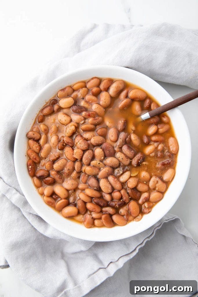 A bowl of savory, smoky slow cooker pinto beans, perfect as a comforting side dish or a versatile base for other Mexican-inspired meals.