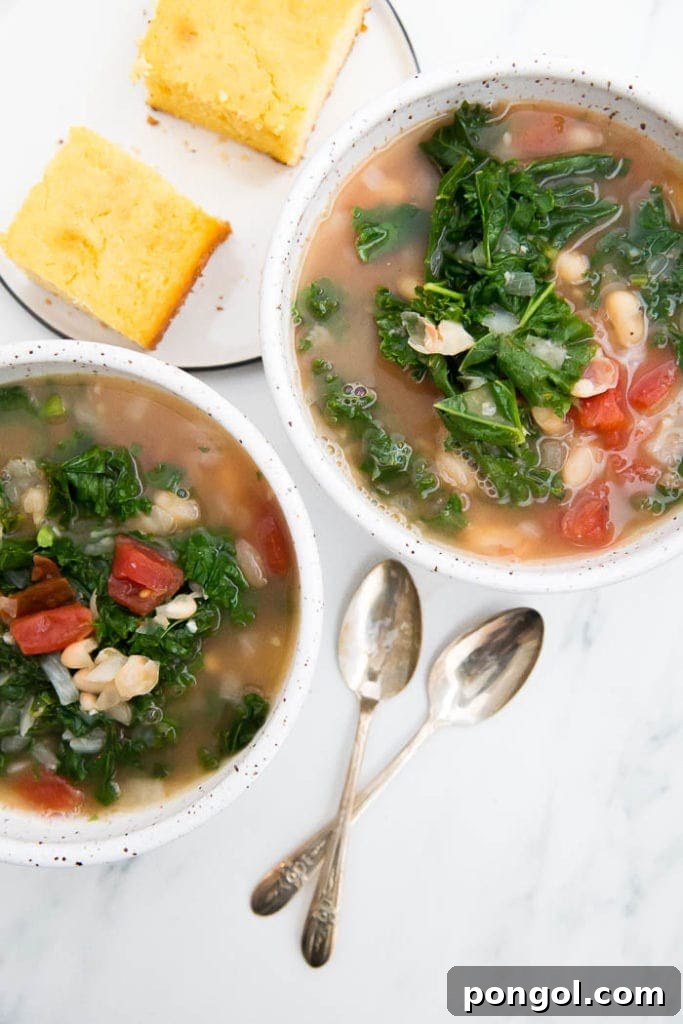A rustic bowl of kale and white bean soup, highlighting the tender green kale leaves and creamy white beans in a flavorful, healthy broth.