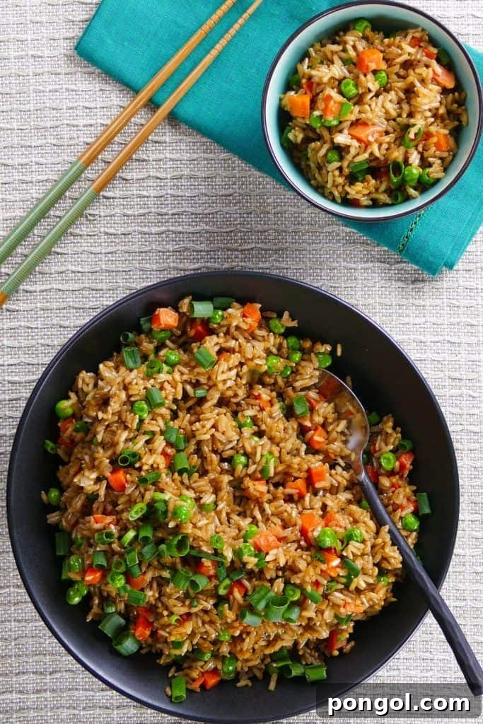 A delicious bowl of chicken fried rice, generously mixed with tender chicken pieces, vegetables, and savory sauce, a classic Asian comfort food.