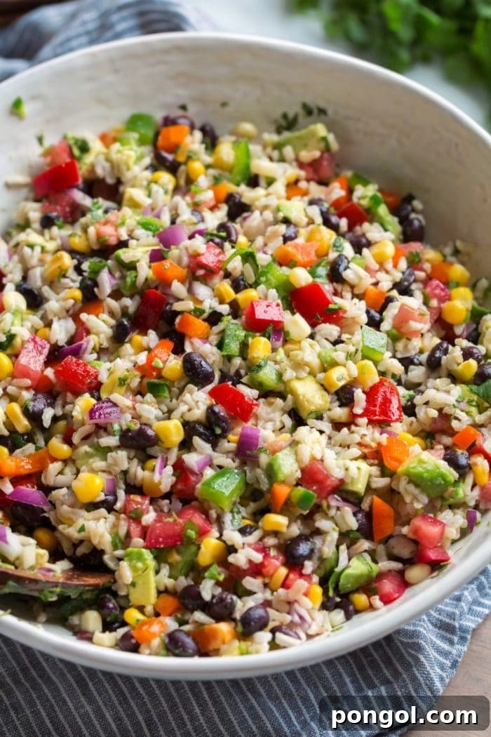 A festive bowl of fiesta rice, colorful with corn, black beans, and diced peppers, offering a vibrant and flavorful side dish.