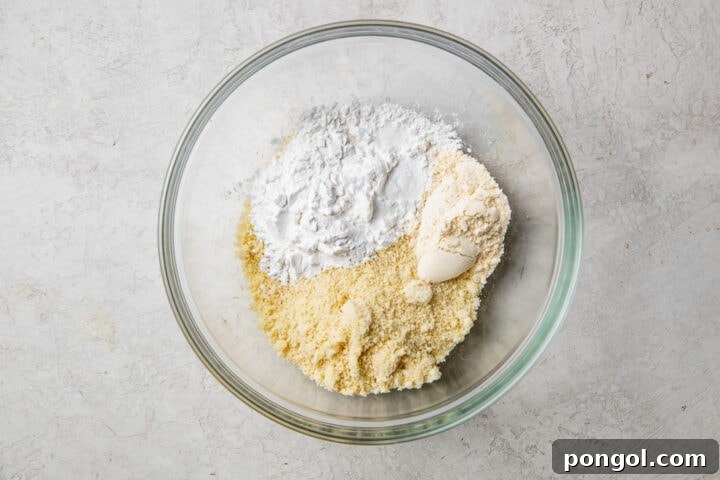 Dry ingredients for paleo pancakes in a glass mixing bowl.