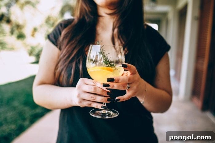 Woman holding a large cocktail glass at a virtual happy hour