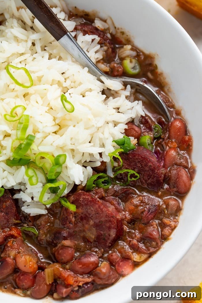 A close-up of creamy Red Beans and Rice in a bowl with a spoon, ready to be enjoyed.
