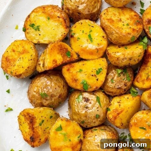 Roasted potatoes on a white platter, perfectly golden and crispy.