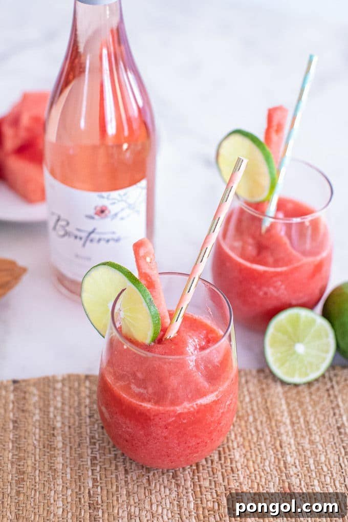 A glass of dazzling bright blue Mermaid Water Rum Punch, artfully garnished with a slice of lime and a maraschino cherry.