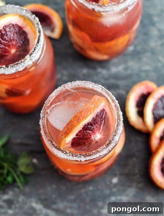 Glasses of exceptionally refreshing Cucumber Vodka Cocktail, artfully garnished with thin cucumber slices and vibrant mint sprigs, perfect for a light, invigorating sip.