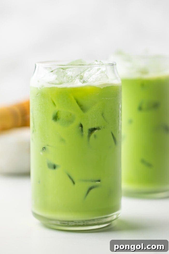 Two beautifully presented glasses of homemade iced matcha latte with ice