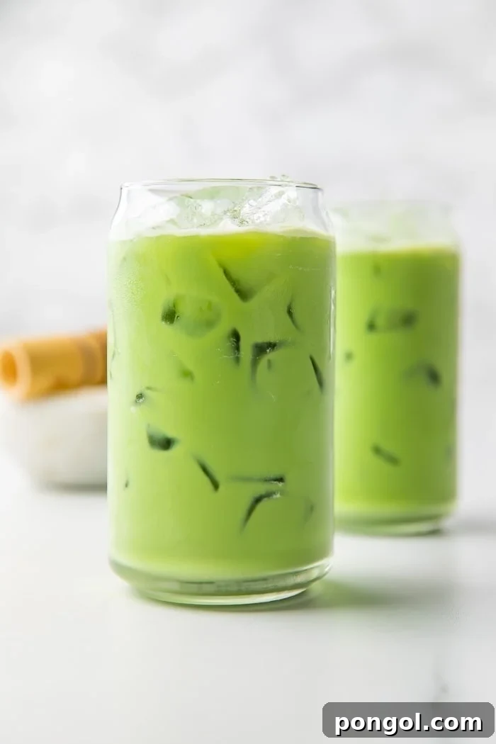 Close-up of two iced matcha lattes, showcasing the vibrant green color and creamy texture