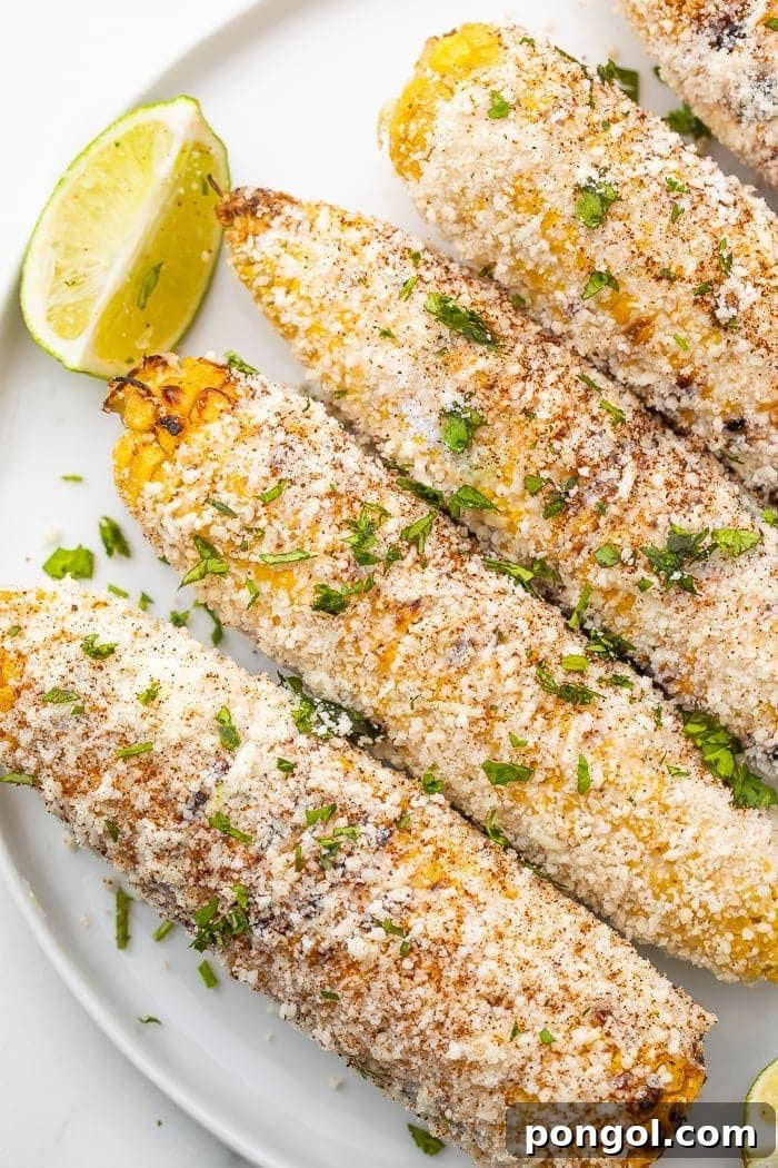 Rolling Elote in Cotija cheese for a delicious coating