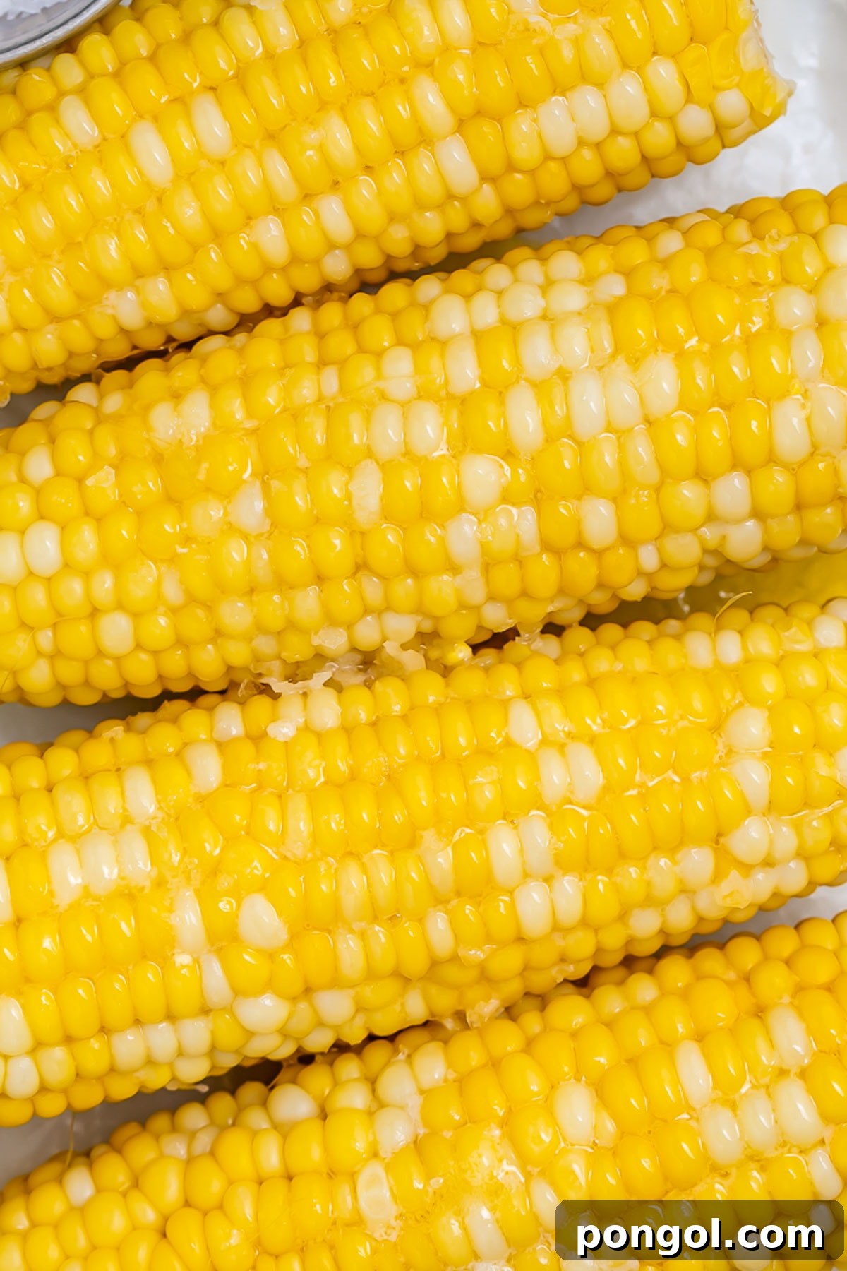 Perfectly Boiled Corn on the Cob 4 Close-up of 4 ears of boiled corn on the cob topped with melty butter.