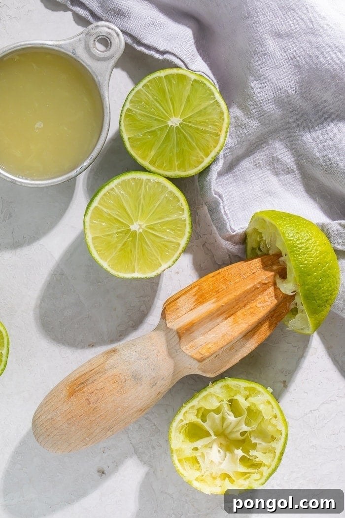 Fresh limes on a cutting board, one cut in half